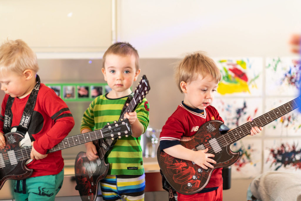 Barnehagebarn som spiller på lekegitarer