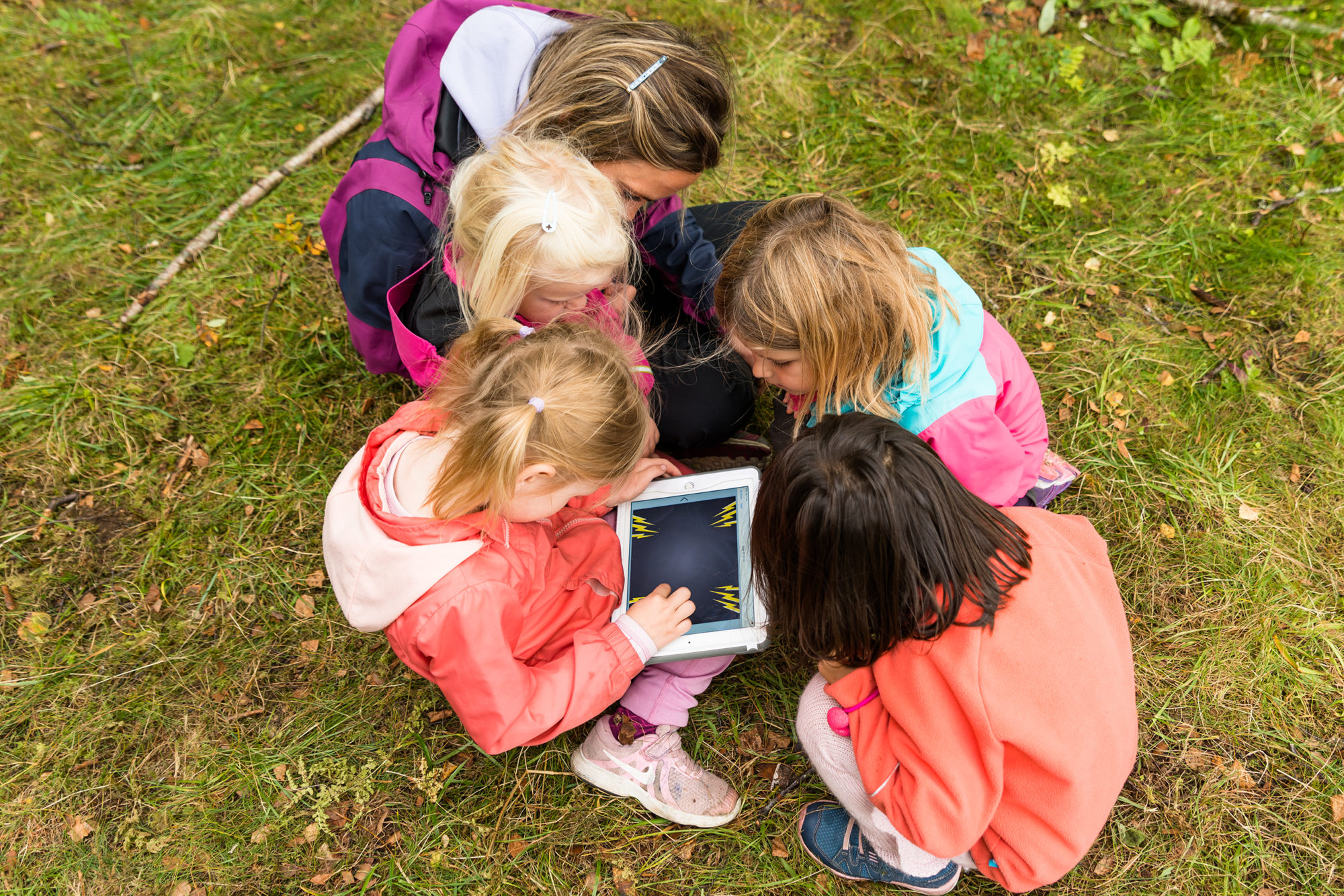 Barnehagebarn lager bildebok på iPad i skogen