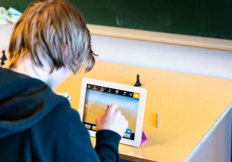 Ungdomsskolegutt som animerer på iPad