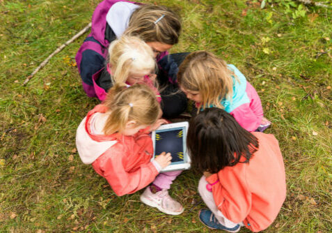 Barnehagebarn lager bildebok på iPad i skogen
