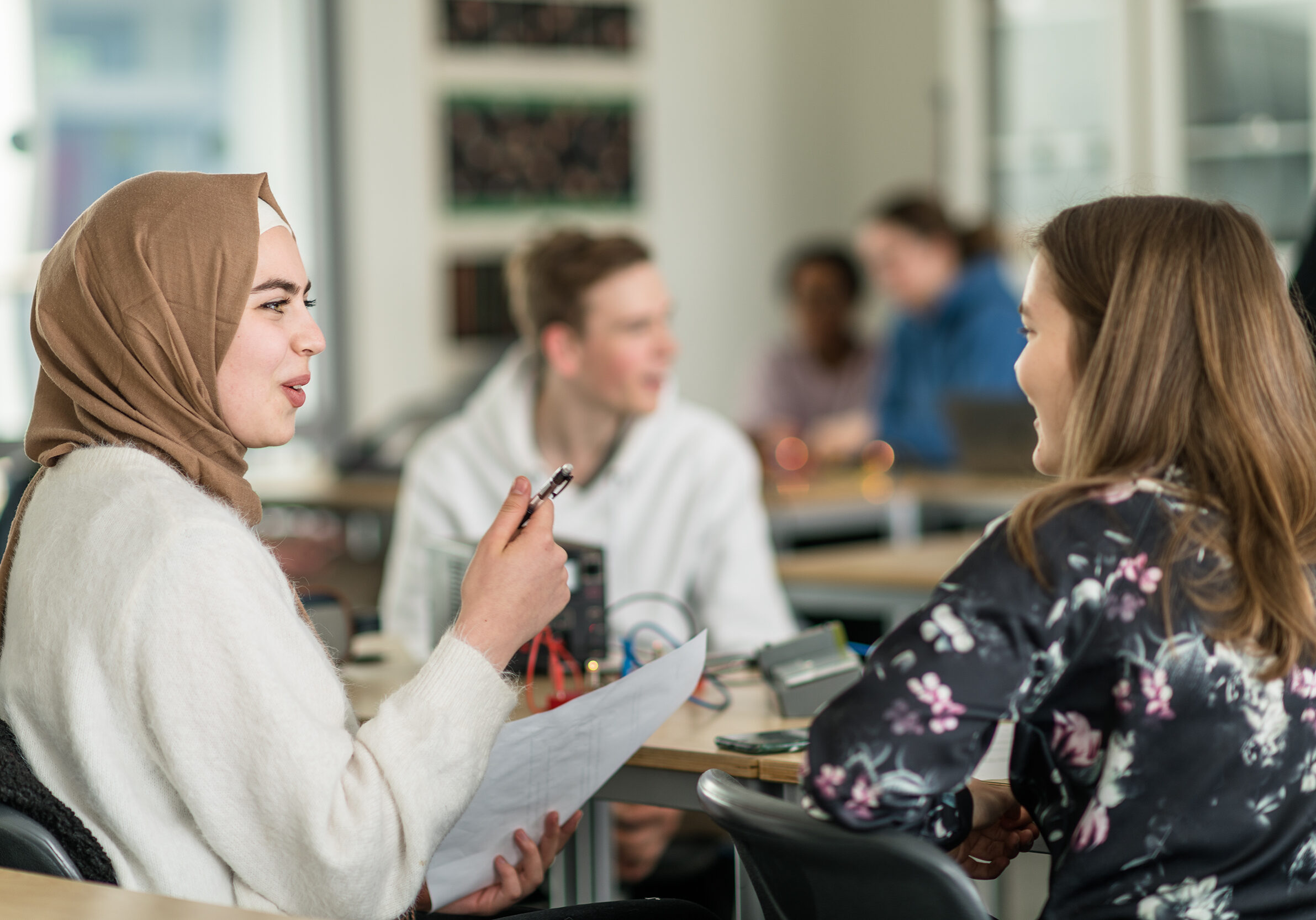 Elever som sitter rundt et bord og diskuterer